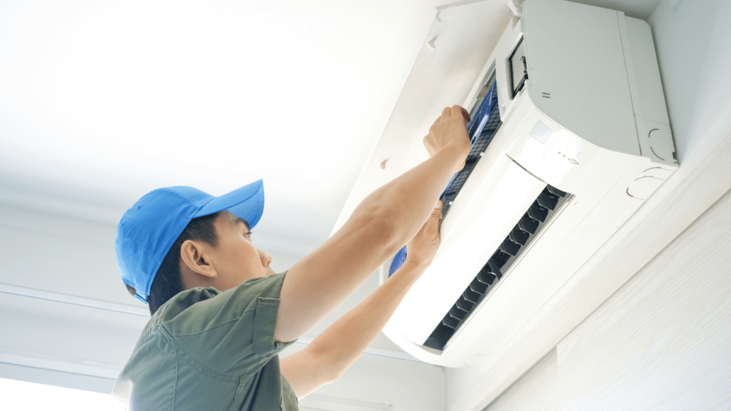 a person cleaning the aircon