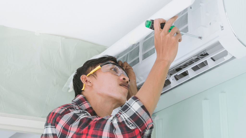 a person cleaning the aircon